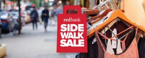 Red Bank Sidewalk Sale logo above an image of a street-side clothes rack